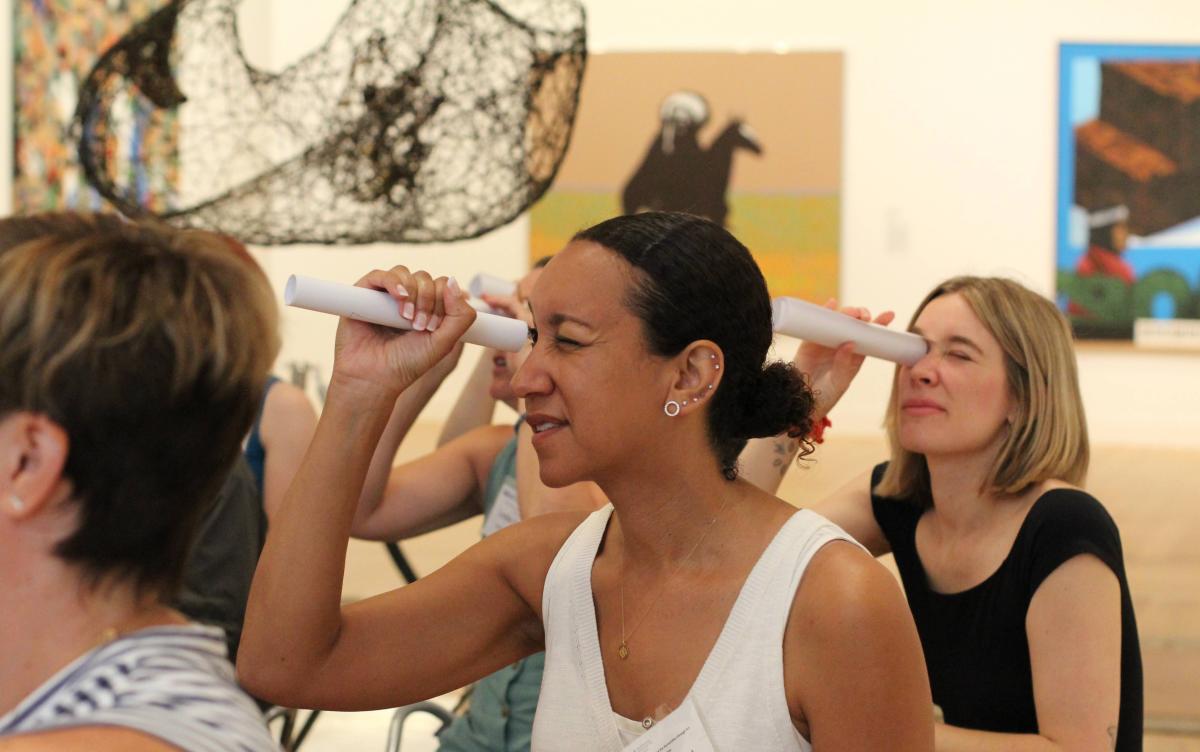 Teachers use paper as telescopes to take a more focused look at the artworks in the gallery