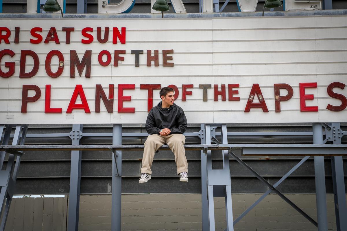 person sitting in front of a theater sign