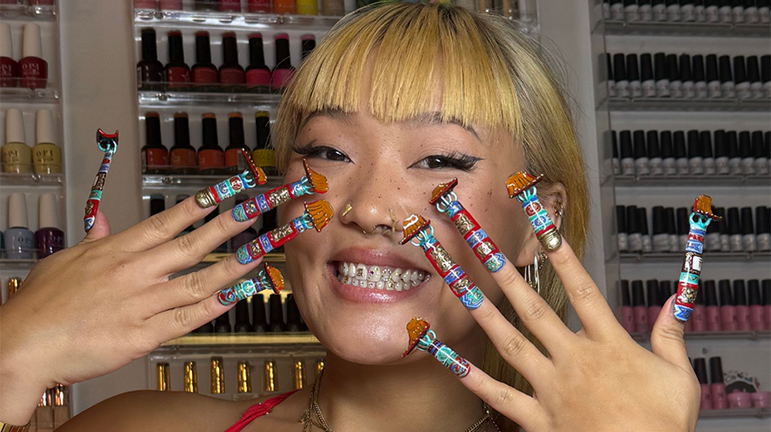 Artist Ameya Okamoto posing with her nail art.