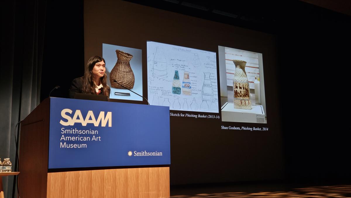 speaker standing at podium talking about three images of baskets