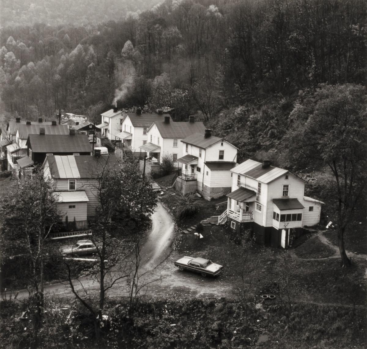 Black and white photograph of a row of houses seen from a distance.