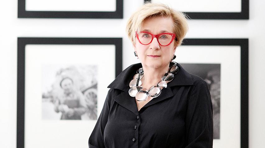 Hartigan standing in front of framed black and white photographs.