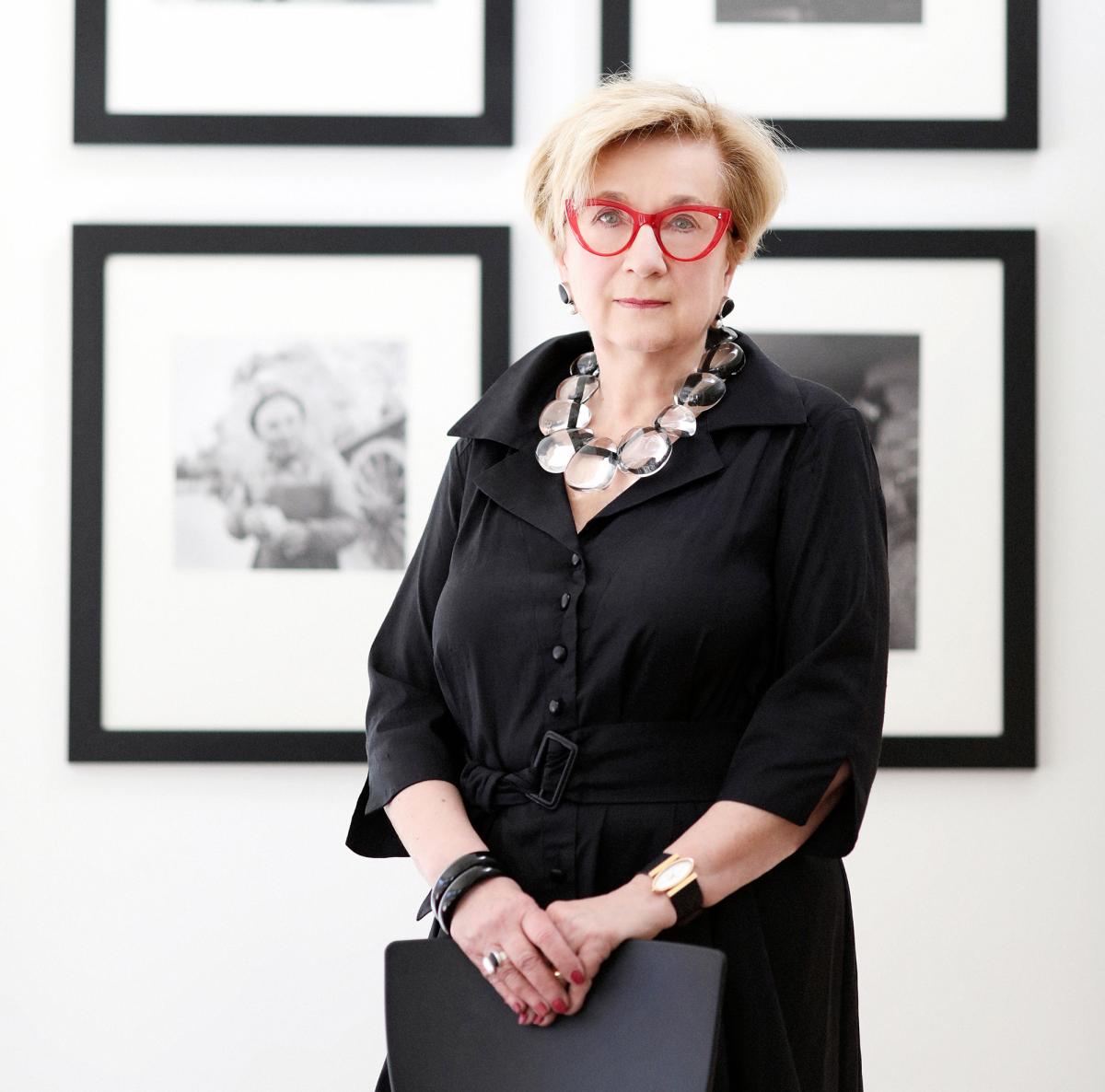Hartigan standing in front of framed black and white photographs.