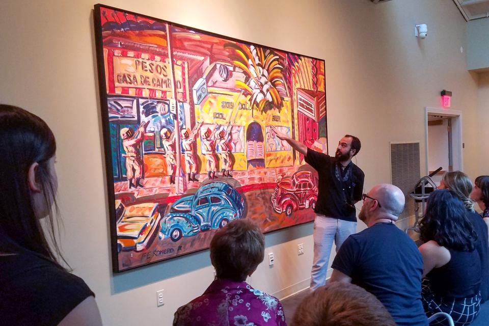 Fellows - Research 50th Wyeth - 3x2 A man lectures in front of a Frank Romero painting