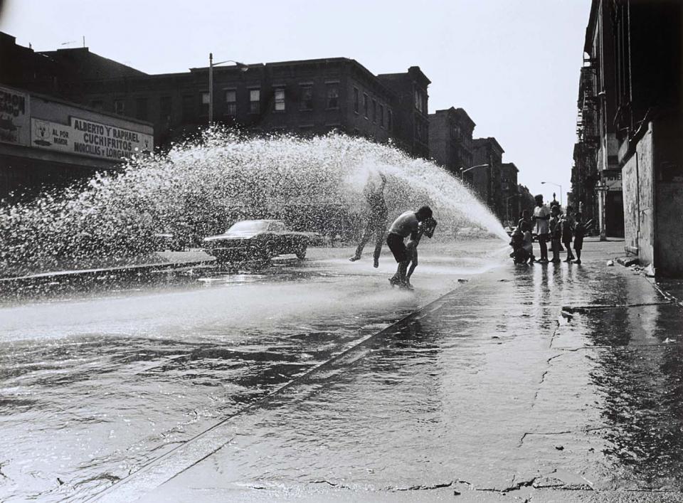 Photograph of children playing in the water from a fire hydrant by Hiram Maristany