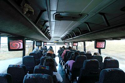 An image inside of a bus from the back of the bus. 