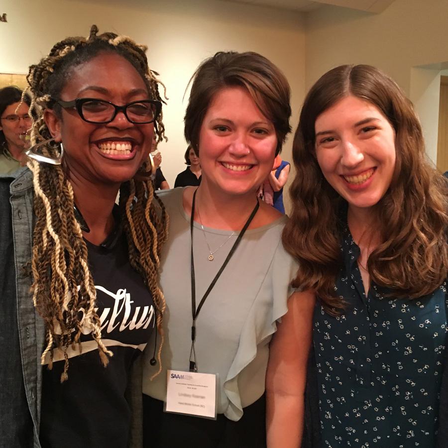 A photograph of three young females smiling. 
