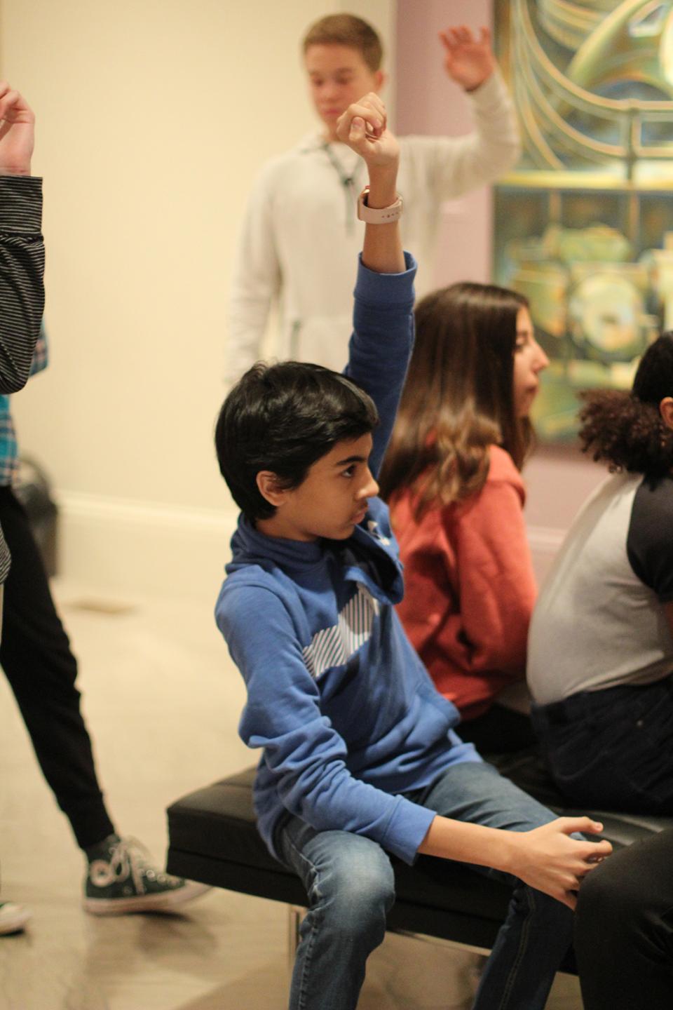 A group of children raising their hands