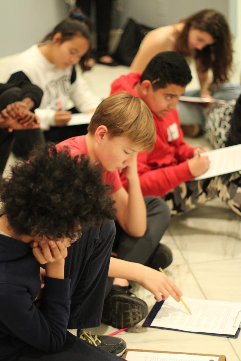 Children sitting on the ground during class.