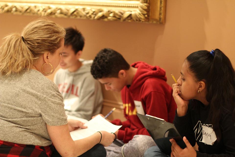 Teens talking with an adult. 