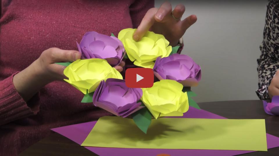 A photograph of a person holding a paper wreath