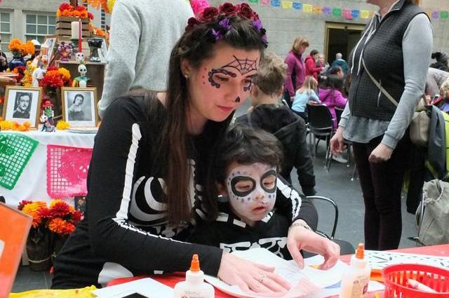 A photograph of a child with his mother making crafts