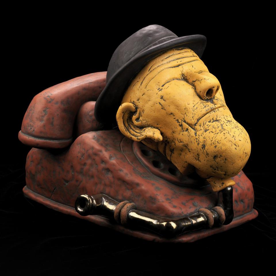 An artwork of a phone with a human head on top. 