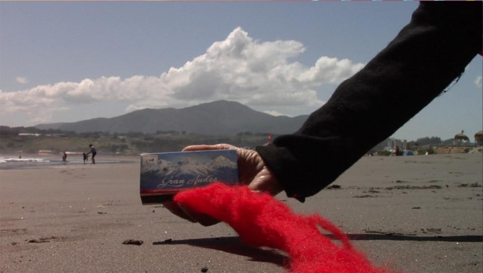 A photograph with mountains in the background and a hand in the foreground.