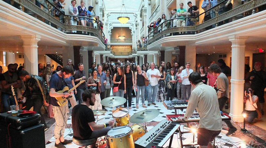 Photo of a band playing music in front of a crowd in the Luce Foundation Center