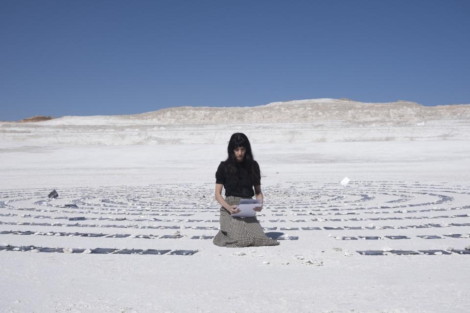 Woman kneeing in the desert