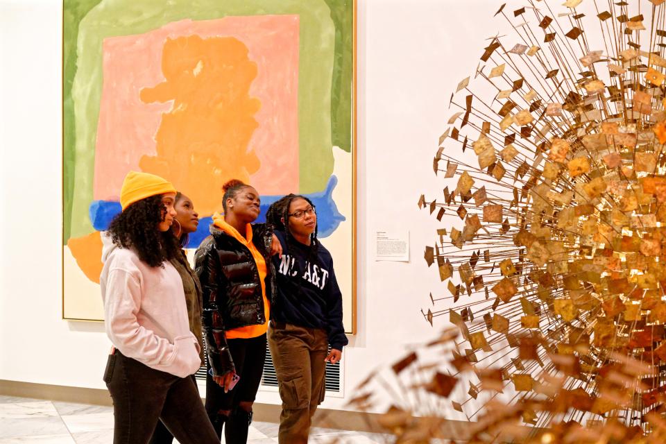 Four young women look at artwork 