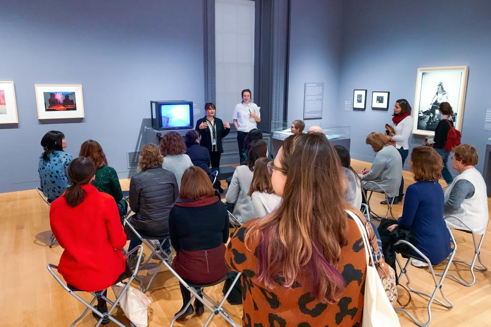 A fellow lectures in front of a group about media art