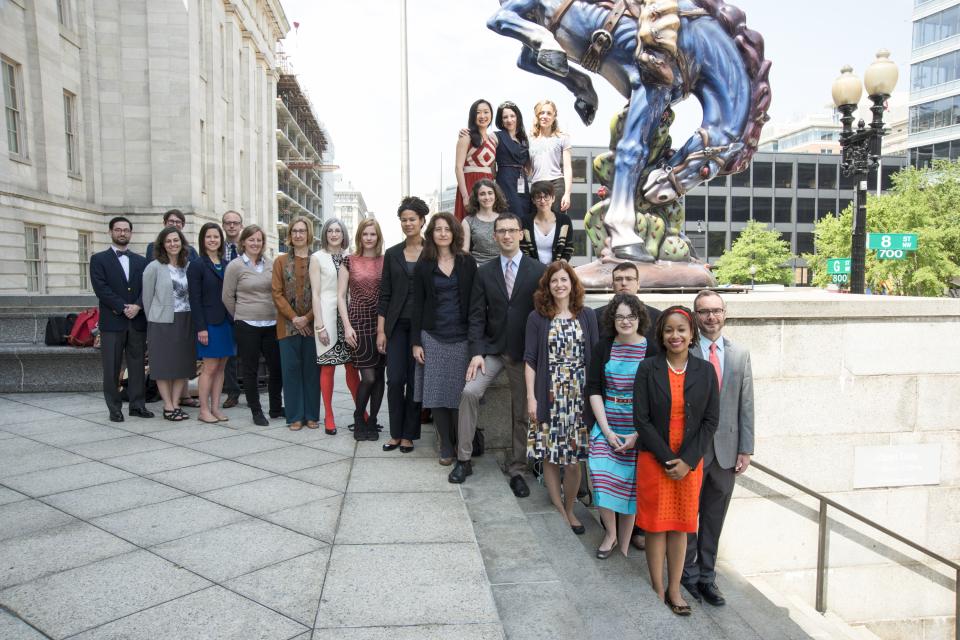 A group of over a dozen fellows pose outside the Smithsonian American Art Museum
