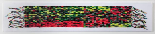 A long, beaded strap in greens and reds. It has fringe on both short ends.