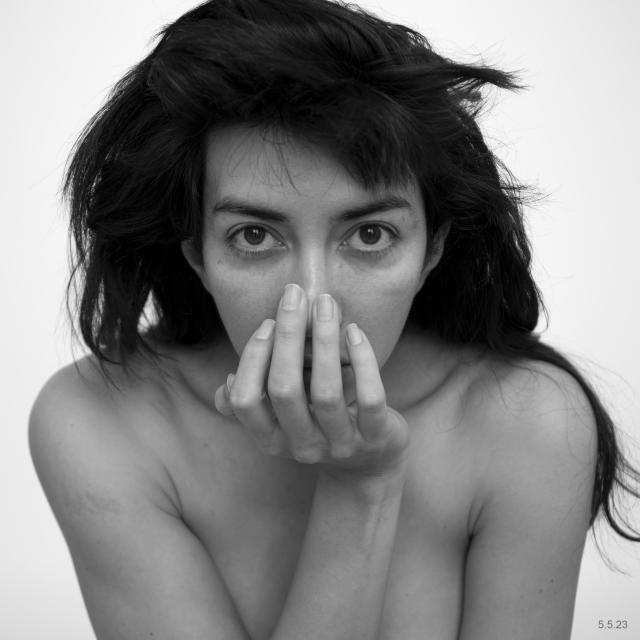 Martine Guitierrez stares directly at the camera with her hand covering her mouth