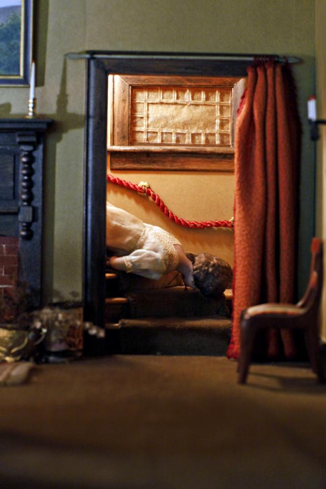 A photograph of a nutshell study of unexplained death showing a detail of a living room.