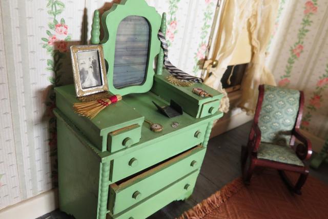 A photograph of a nutshell study of unexplained death showing a detail of a dresser.