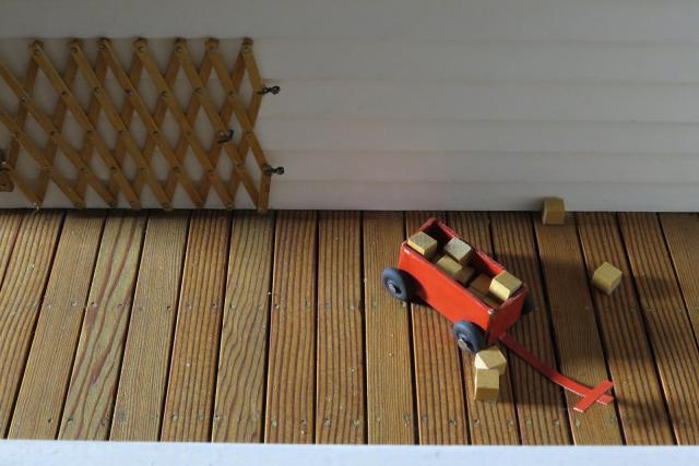 A photograph of a nutshell study of unexplained death showing a detail of children's toy on a porch.