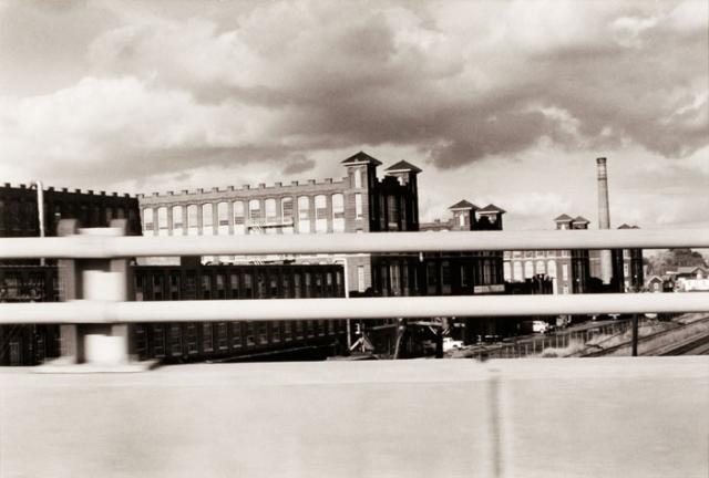 A photograph of a Connecticut landscape with a building taken by automobile.