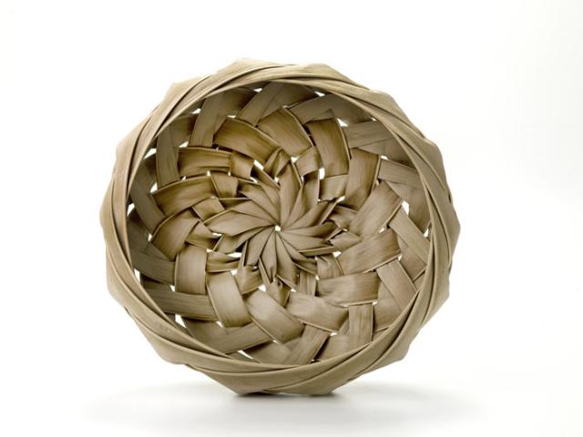A basket that is small and round with a spiral pattern weave.