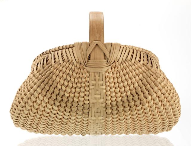 A basket that has a bigger base and compresses as it gets closer to the handle.