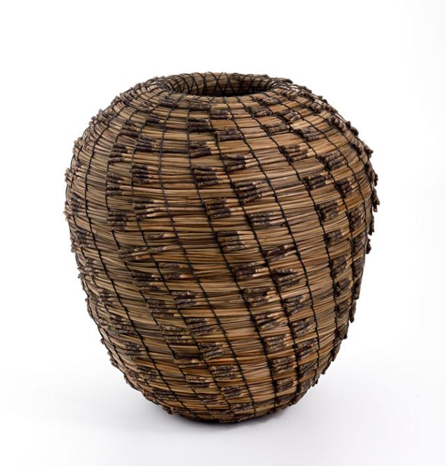 A basket that is long with a small top and bottom that flares out in the middle.