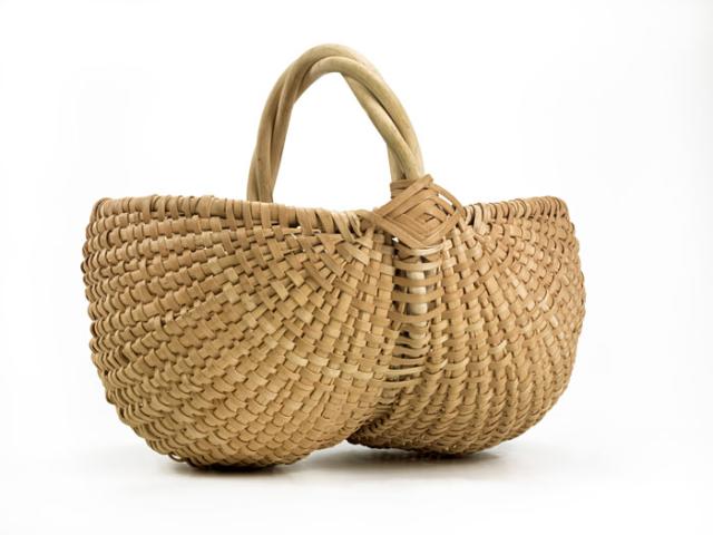 A basket with two circular sides that come together in the middle and are connected to a handle.