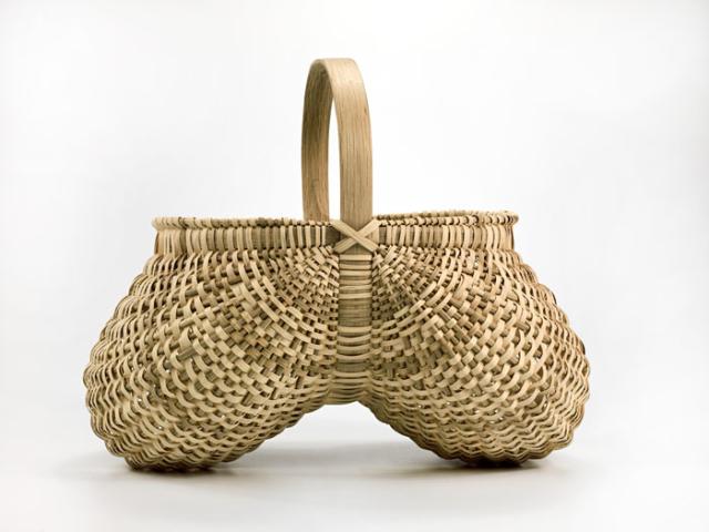 A basket with two circular sides that come together in the middle and are connected to a handle.