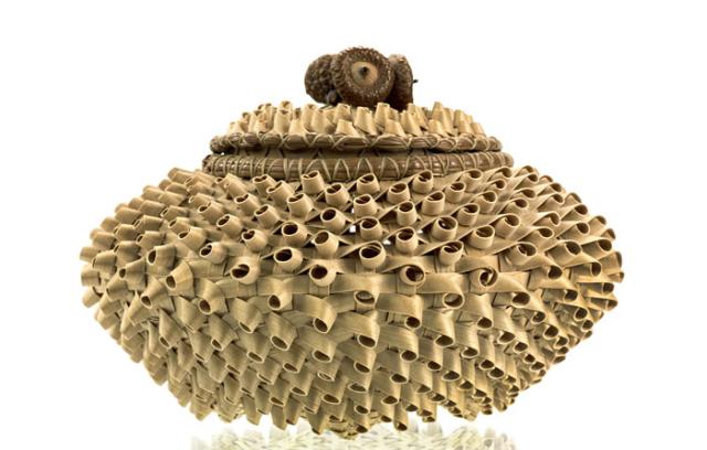 A unique basket that's circular with a woven pattern that creates a small circular texture on the outside.