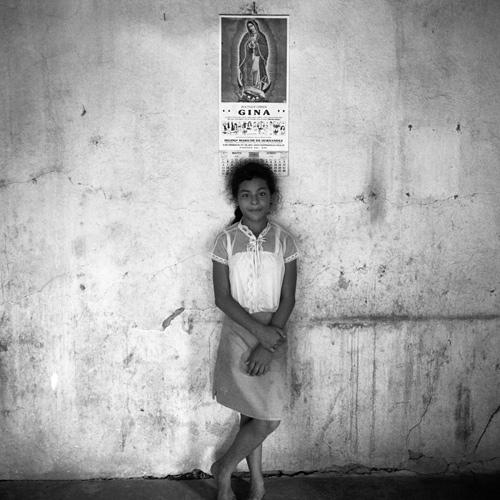 Gleaton's gelatin silver print of a girl against a wall.