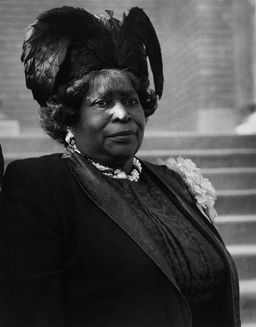Hudnall's gelatin silver print of a portrait of a lady with a elaborate hat with feathers. 