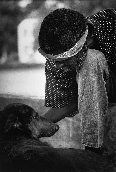Hudnall's gelatin silver print of a man petting a dog. 