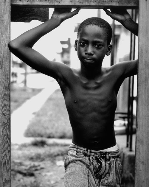 Hudnall's gelatin silver print of a boy posing in a frame.