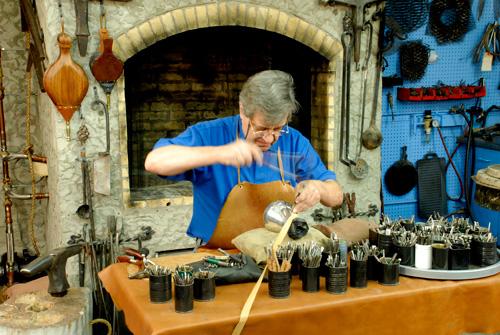 This is a photo of artist Ubaldo Vitali in his studio making artwork.