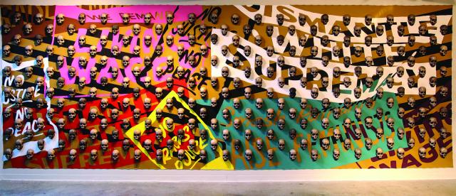 An image of an installation on a wall with skulls and many background colors.