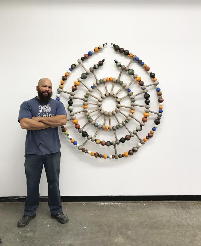 An image of a circular sculpture with small elements in different colors.