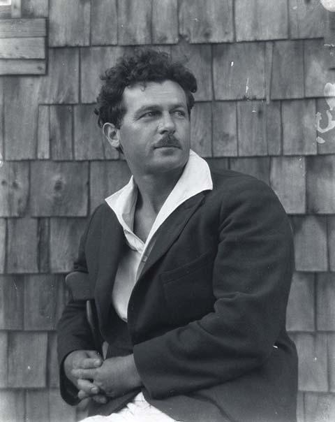 A black and white photograph of a man sitting in a chair. 