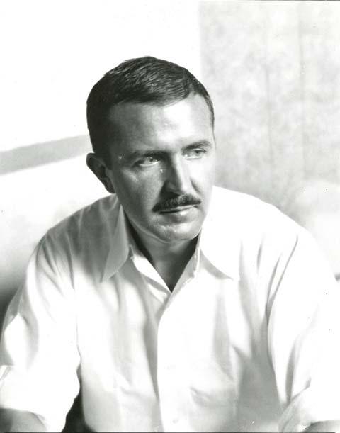 A black and white photograph of a man sitting down.