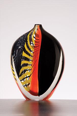 A black, orange, and yellow glass vessel.