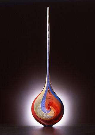 A glass vessel that looks like a long tear drop.