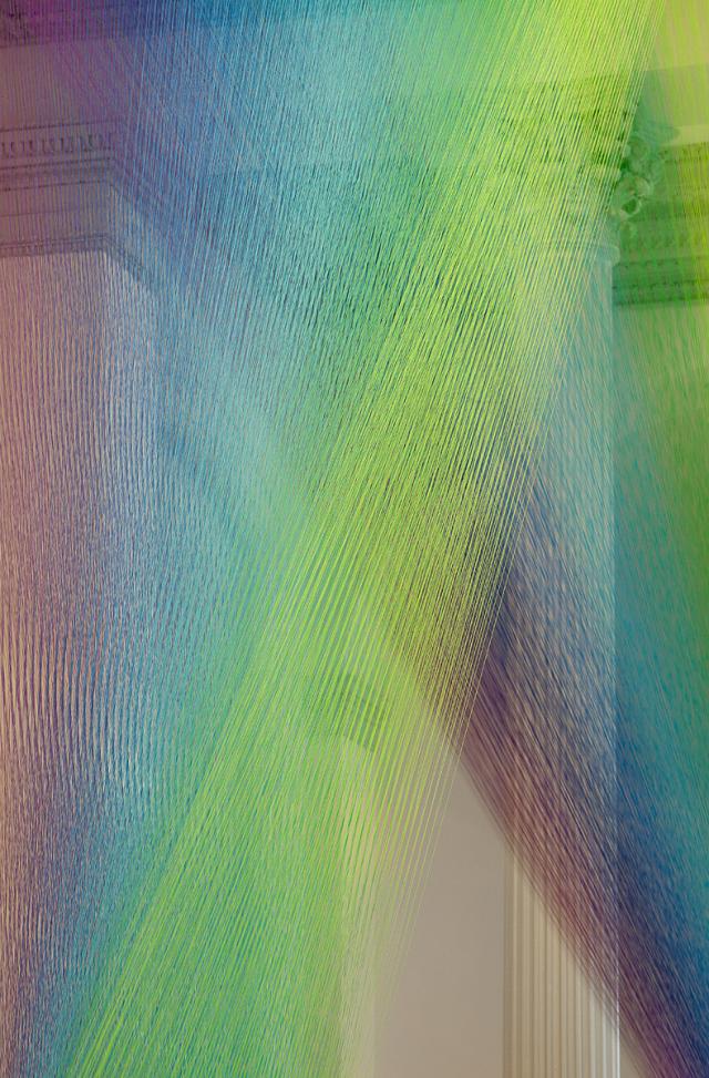 Colorful string crossing itself to create a rainbow affect.