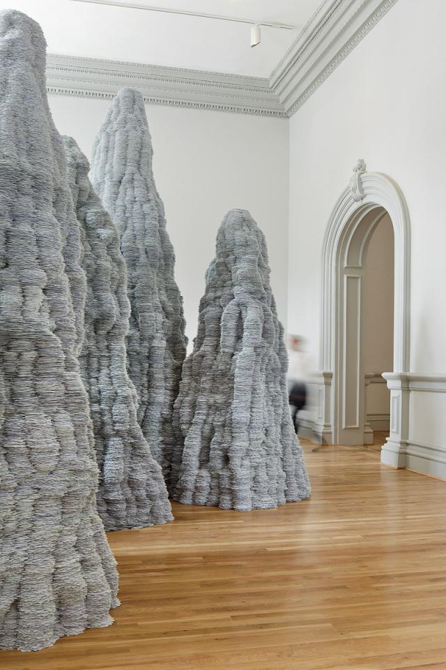 A photograph of paper stacked up to the ceiling inside a room.