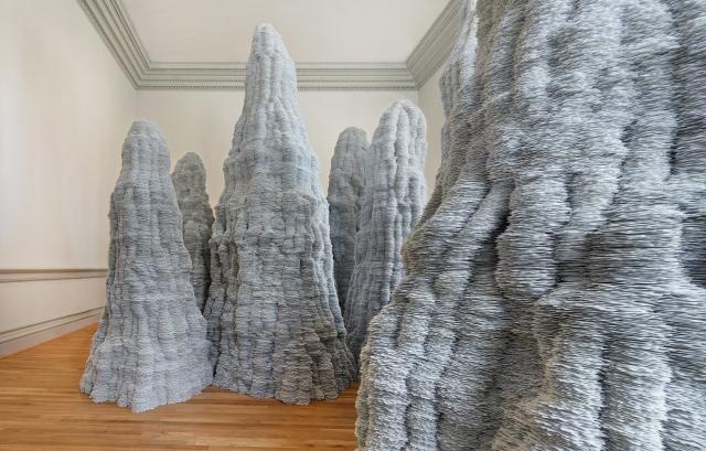 A photograph of paper stacked up to the ceiling inside a room.