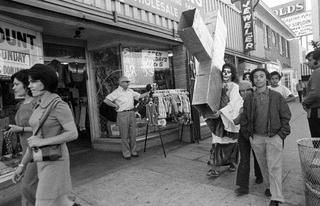 A photograph of a person carrying a cross through a city.